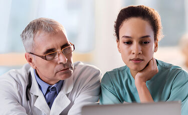 physician and nurse looking at laptop