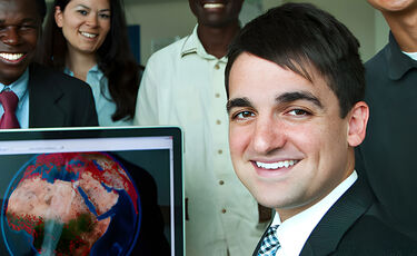 young man with computer and colleagues